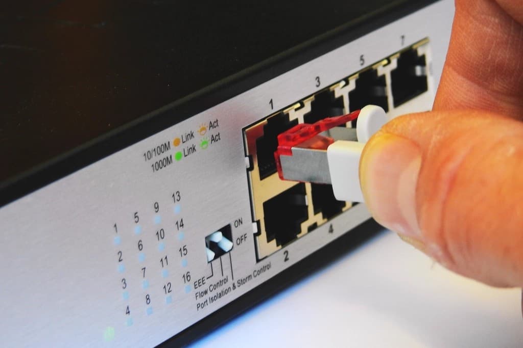Technician connecting a cable to a network switch